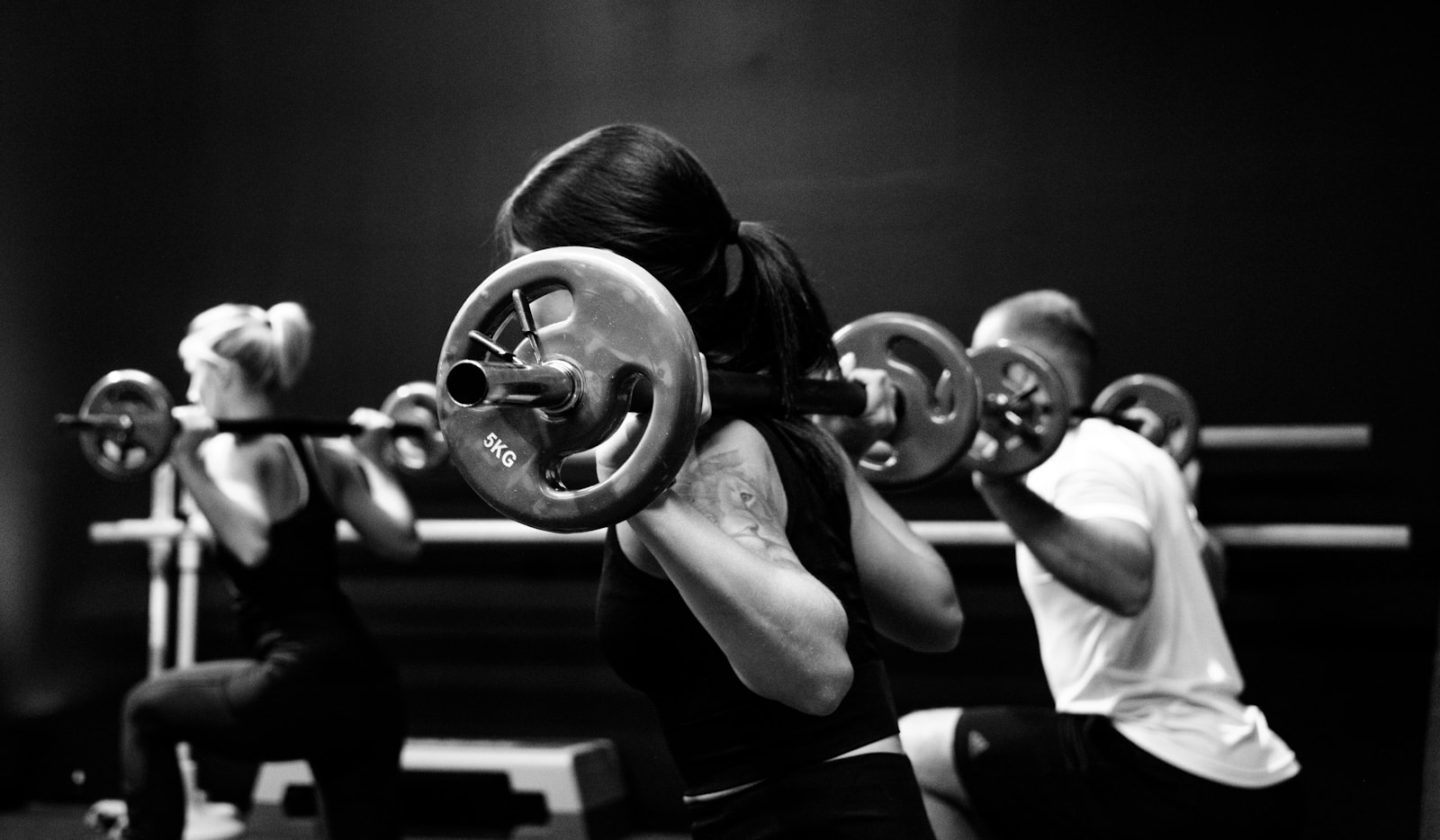 Pies z głową w dół – jak wykonać poprawnie tę pozycję jogi? three person lifting barbels
